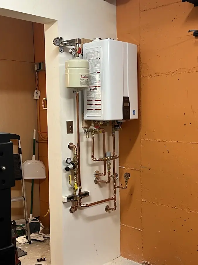 Plumbing technician inspecting water heater connections in Glasgow Village